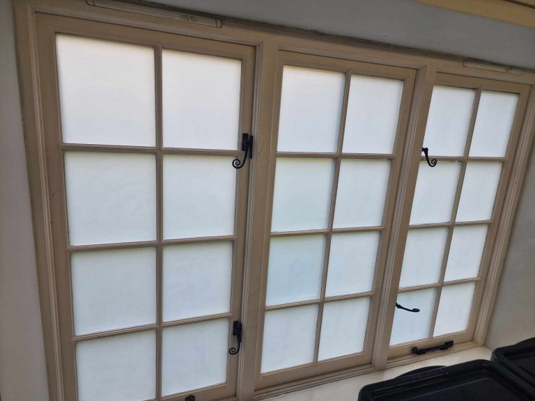 Privacy window film installation Privacy window film fitted to glazed doors to reduce glare and improve privacy