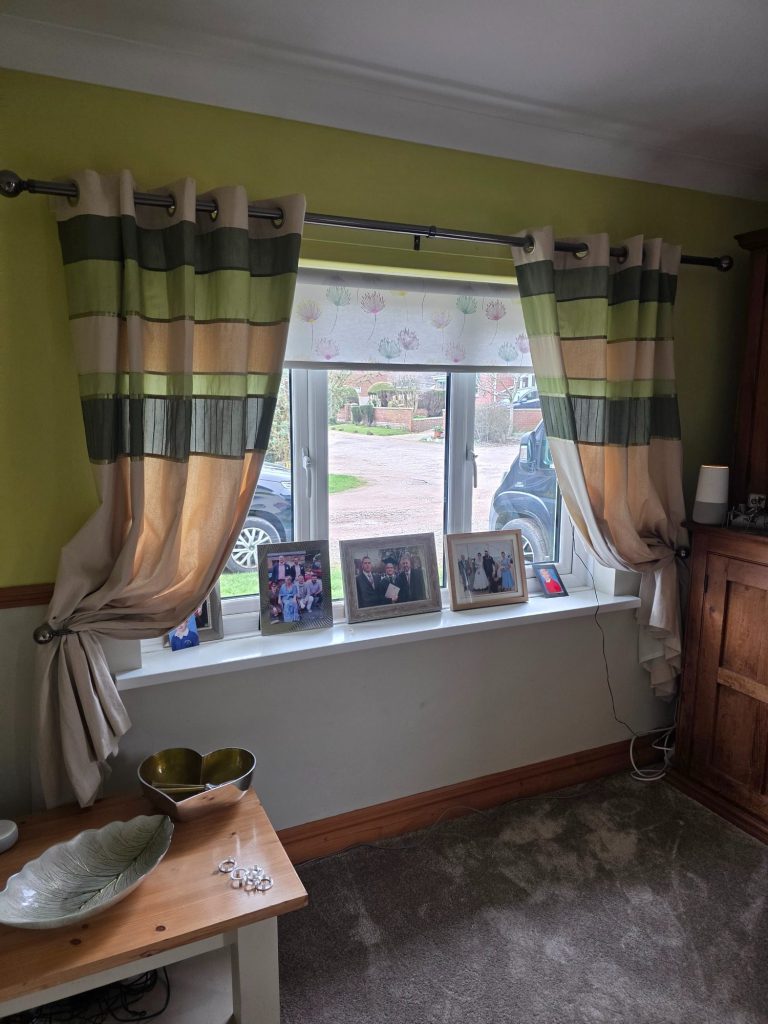 Motorised blind with curtains Motorised roller blind fitted behind existing curtains to improve light control while keeping the room’s soft furnished look