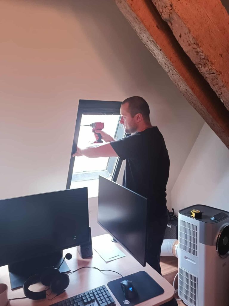 Awkward window blind installation Custom blackout blind being professionally installed to an angled roof window in a vaulted ceiling room